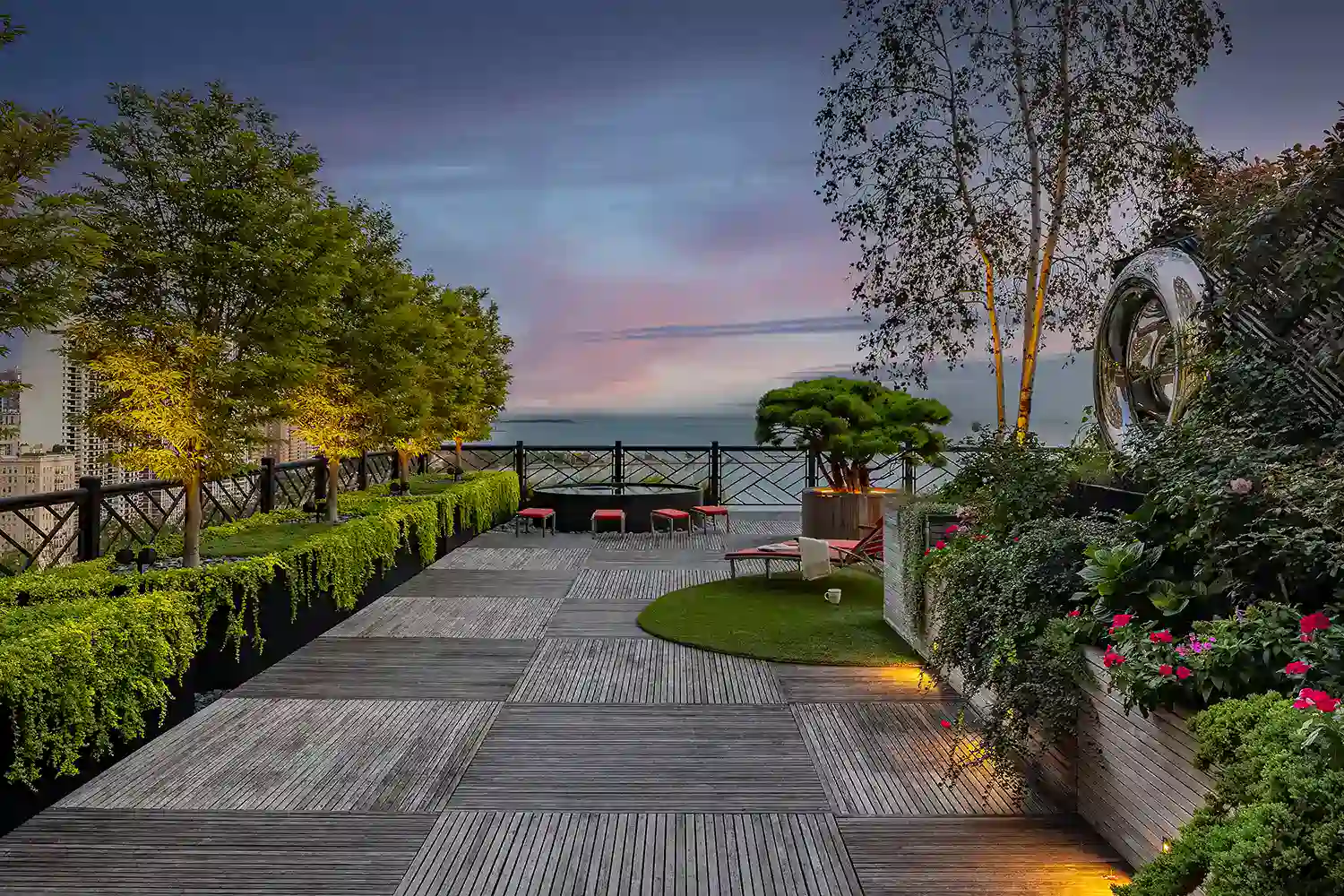 A wooden deck with a view of the ocean at dusk.